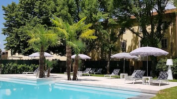 En säsongsöppen utomhuspool, infinity-bassäng, parasoller och solstolar