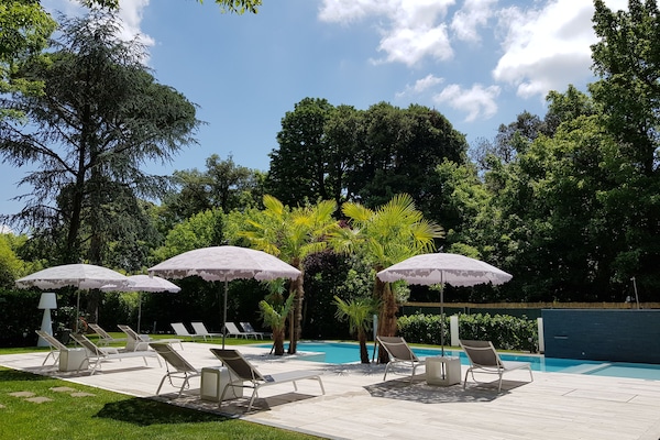 Una piscina al aire libre de temporada, una piscina infinita, sombrillas