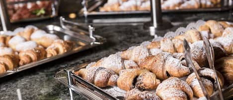 A buffet with various pastries and desserts.