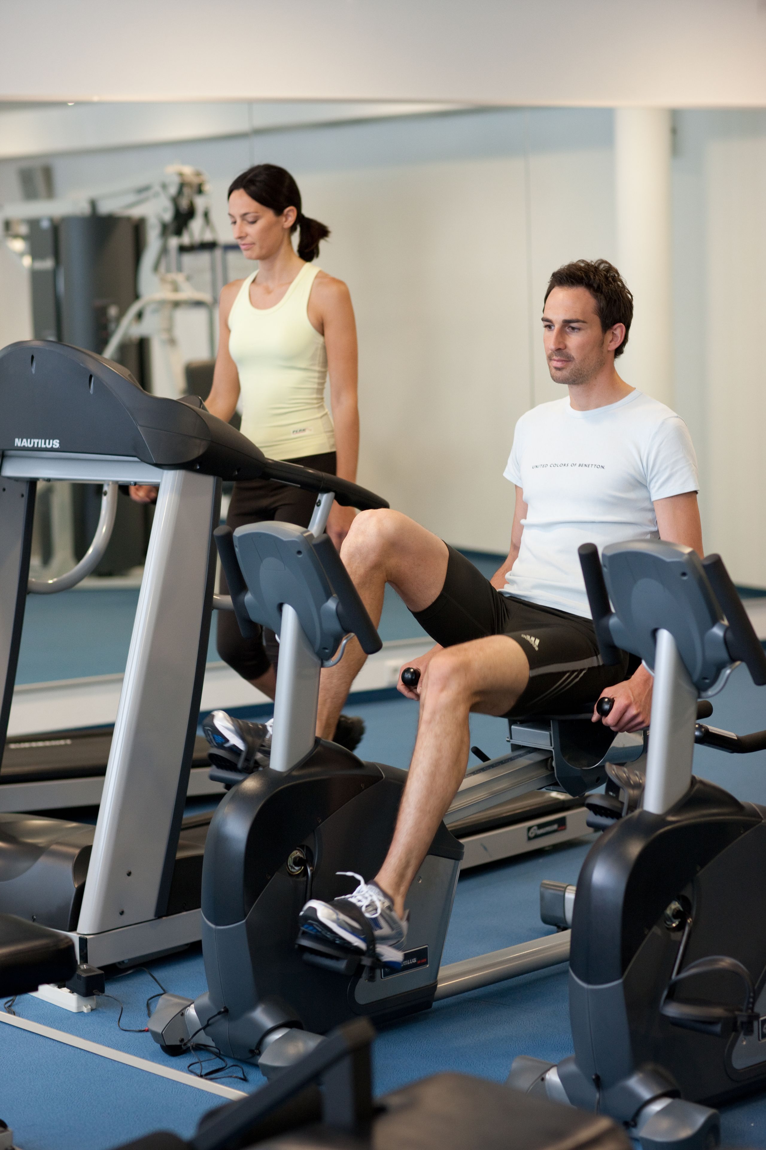 Een sportschool met loopbanden en fitnessapparatuur.