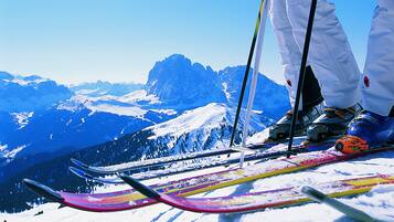 A ski slope with snow-covered mountains in the background.