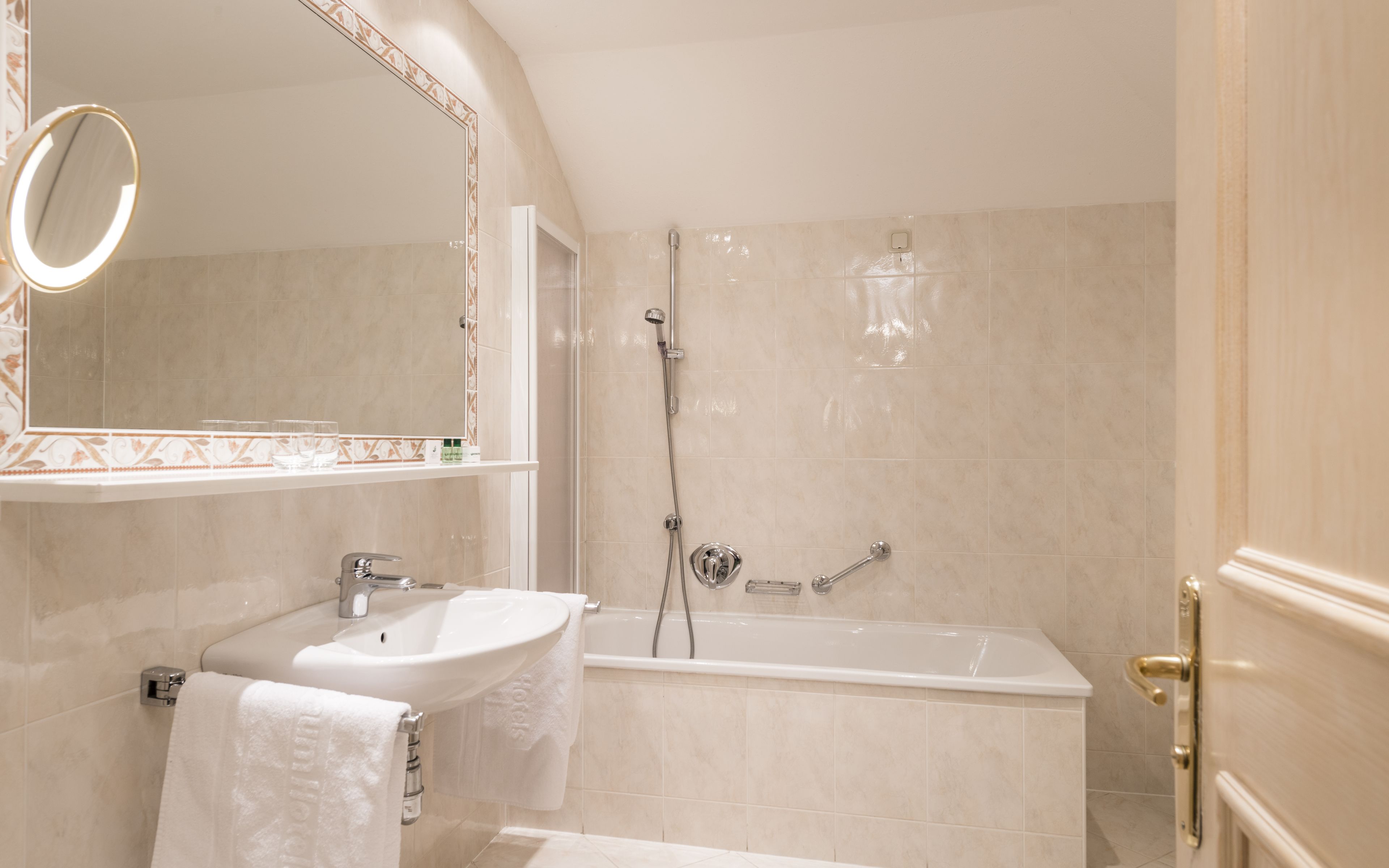 Ein Badezimmer mit Waschbecken, Spiegel und Badewanne.
