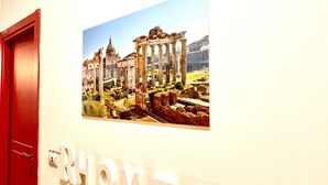 Un pasillo con un letrero en la pared que dice "RHOME 86" e ilustración de ruinas antiguas.