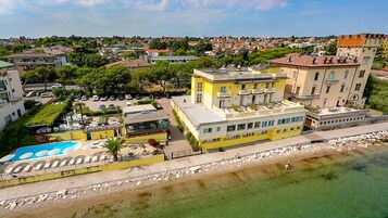 Un hotel frente al mar con piscina, varias plantas y vistas al océano.