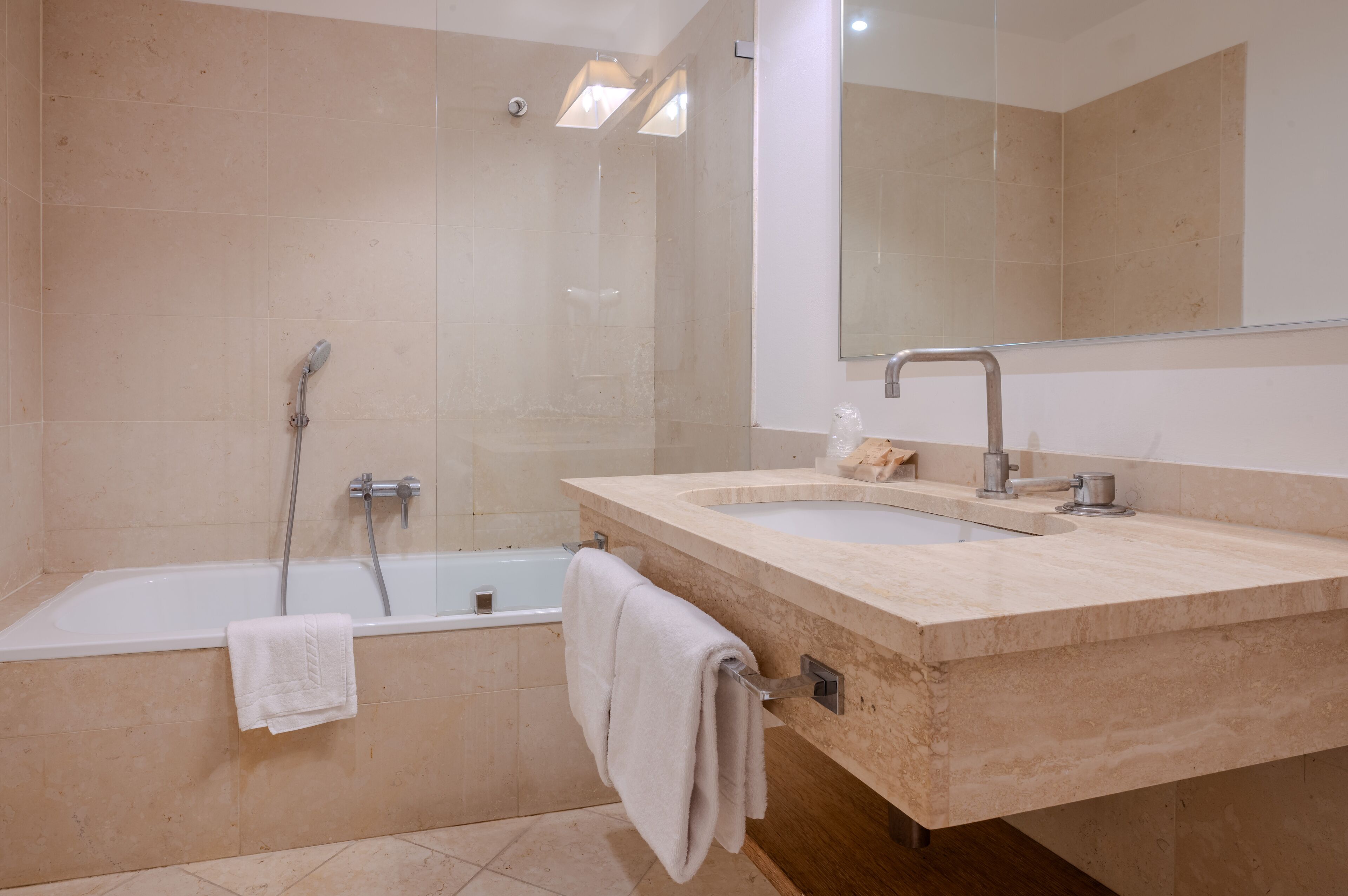 A modern bathroom with a bathtub, a sink, and a large mirror.