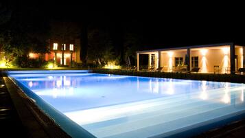 Alberca al aire libre, sombrillas en la alberca y camastros