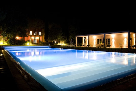 Una piscina al aire libre, sombrillas, sillones reclinables de piscina. Villa Il Palagio
