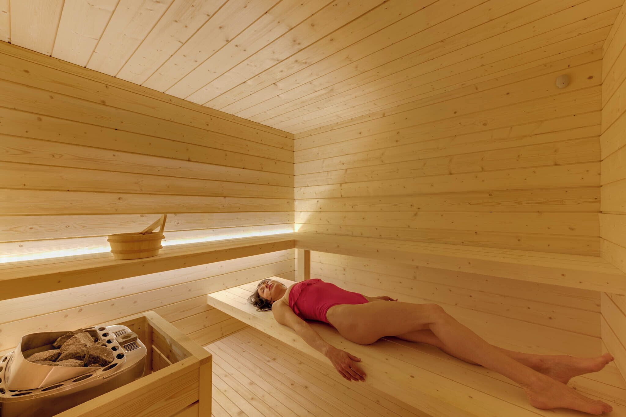 Un sauna en bois, doté de bancs et d’un générateur de vapeur.