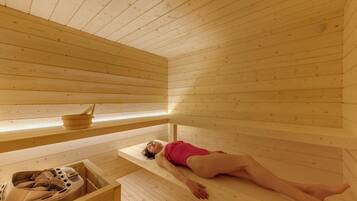 Una sauna de madera con bancos y un generador de vapor.