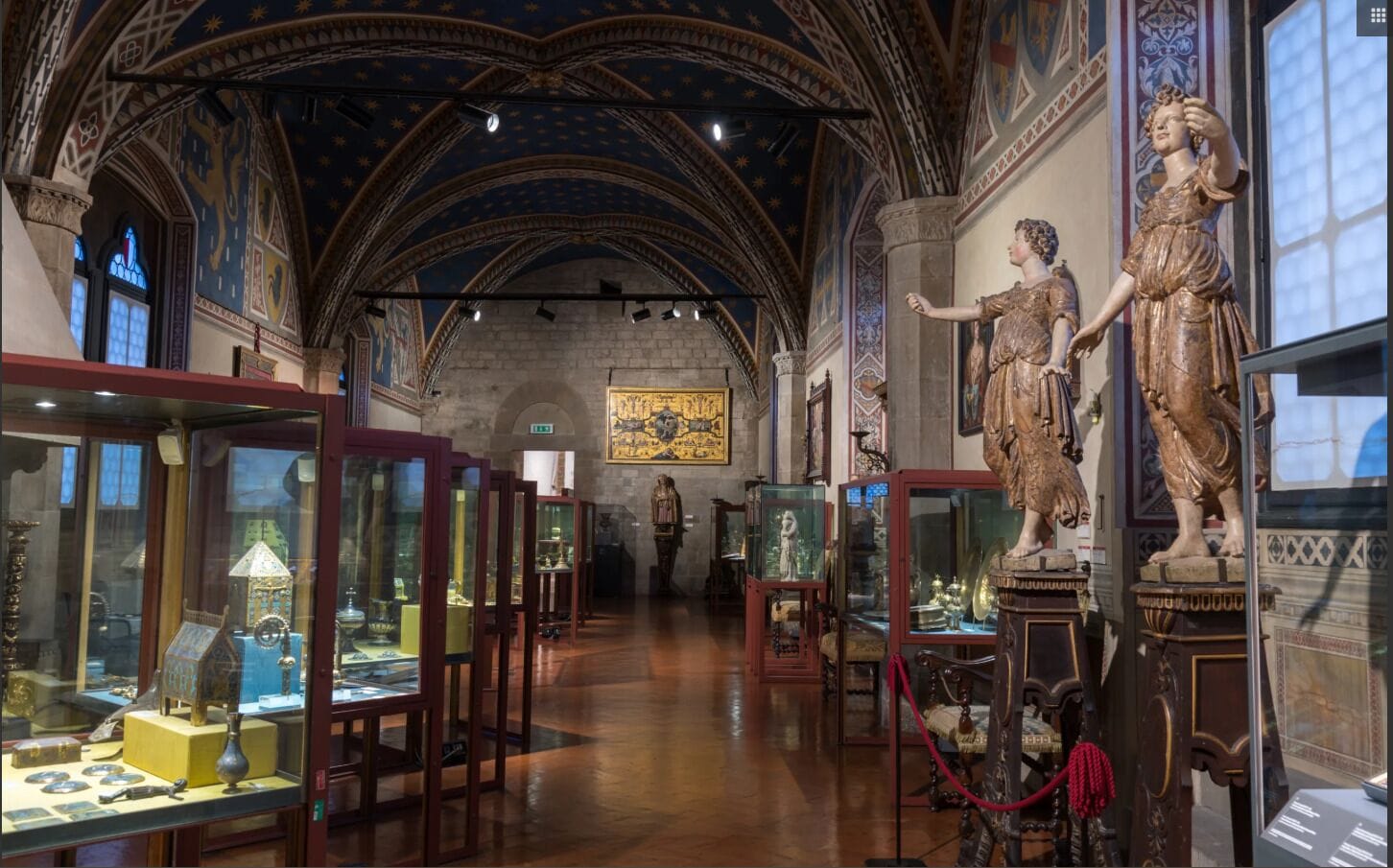 Un interior con techos abovedados, vitrinas de cristal y estatuas clásicas.