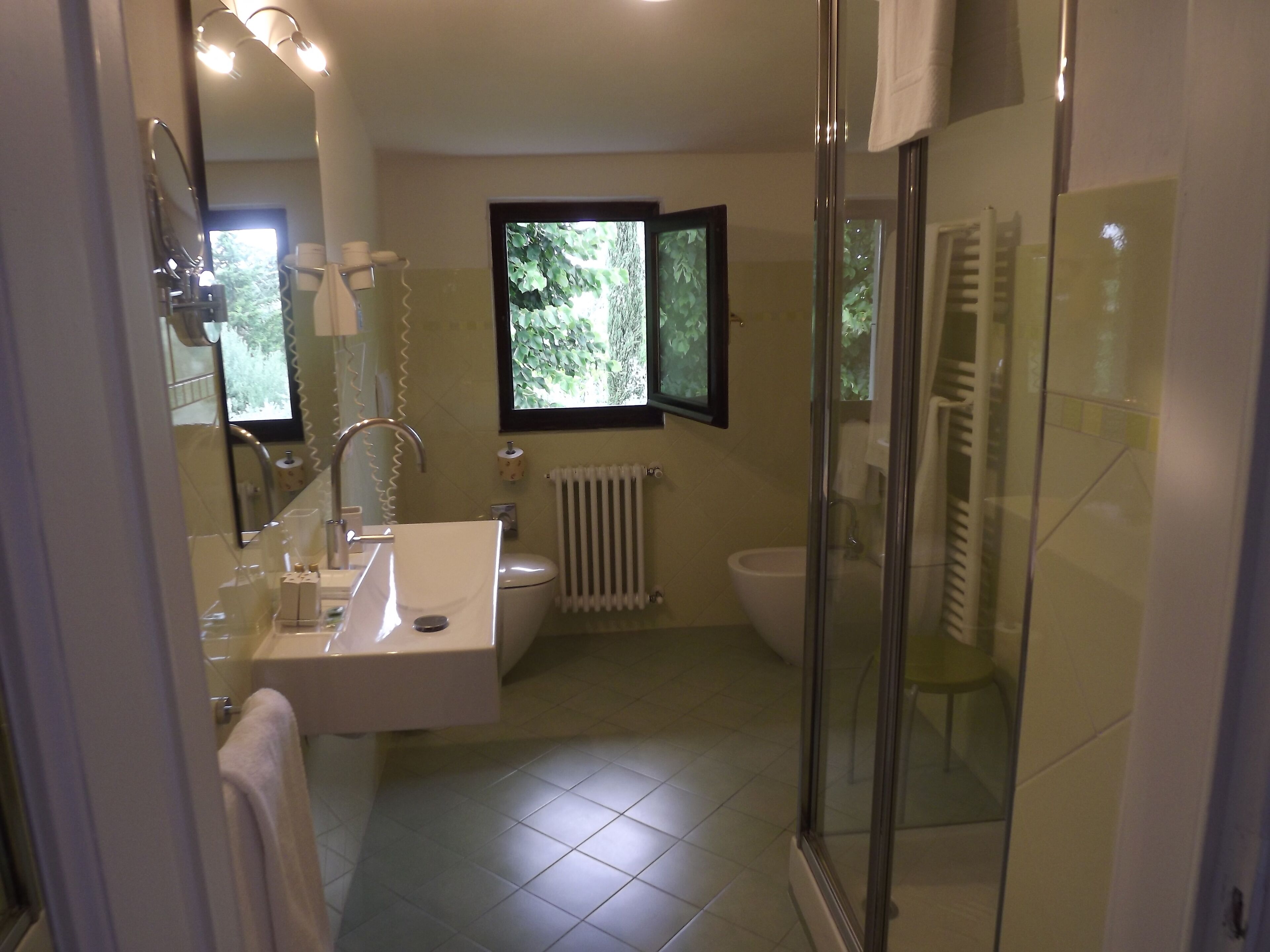 Un baño moderno con cabina de ducha de vidrio, un lavamanos blanco y un inodoro.