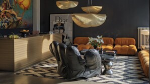 Una sala de estar moderna con un sillón de cuero, un mostrador de recepción y un juego de sofás.