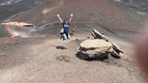 A person jumping in a volcanic landscape with a mountain in the background. - Etna Bed & Breakfast (Belpasso)