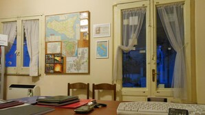A room with a desk, a map, a keyboard, and a window with curtains. - Etna Bed & Breakfast (Belpasso)