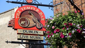 A sign for "The Temple Bar" with a vintage design, indicating live music and a historical establishment. - Baggot Court Townhouse (Dublin)