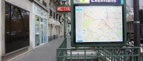 A bus stop with a map display and a sign for 'Exelmans' metro station.