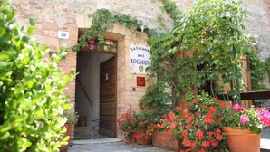Un edificio rústico de piedra con un letrero que dice 'La Locanda del Loggiato' y el número '30' sobre la entrada.