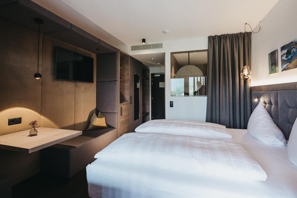 Ein modernes Hotelzimmer mit einem großen Bett, einem Schreibtisch und einer Sitzecke.