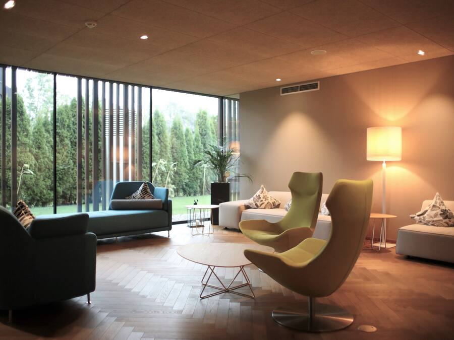Una sala de estar moderna con un ventanal grande, una mesa redonda y muebles contemporáneos.