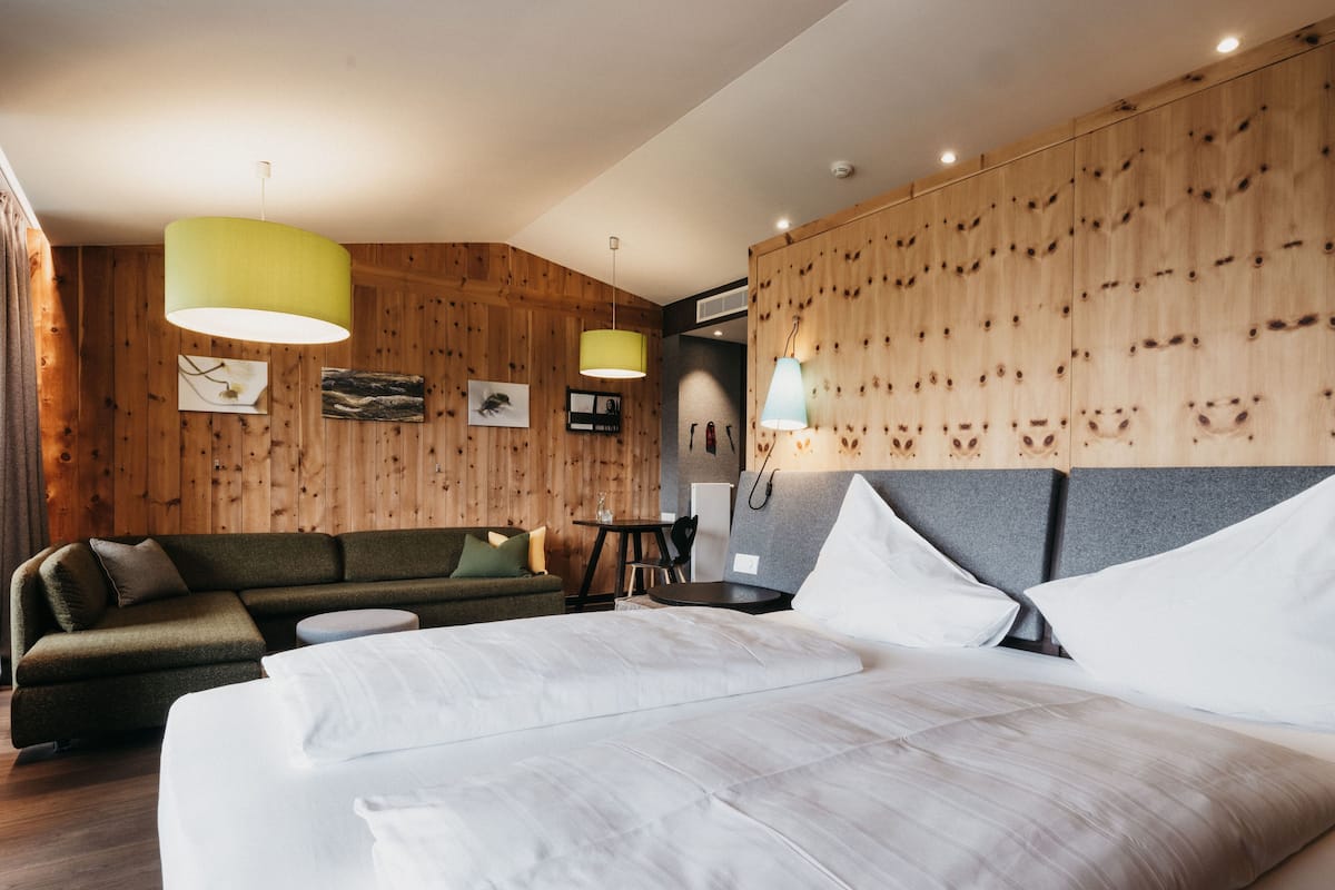 Ein modernes Hotelzimmer mit einem großen Bett, einer Sitzecke und einem Essbereich.