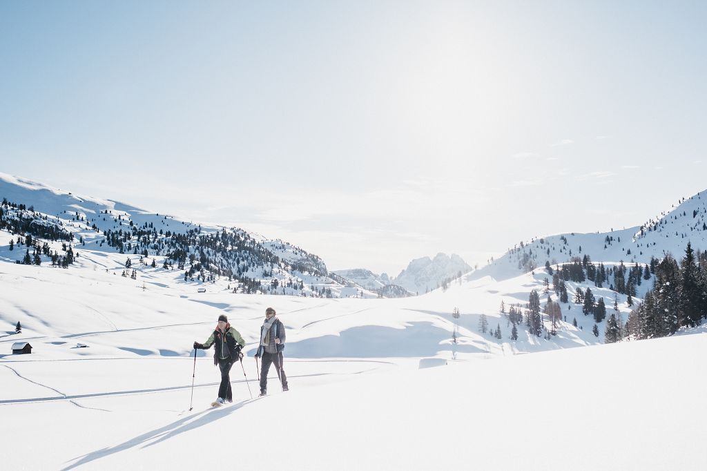 Eine verschneite Berglandschaft mit zwei Skifahrern.