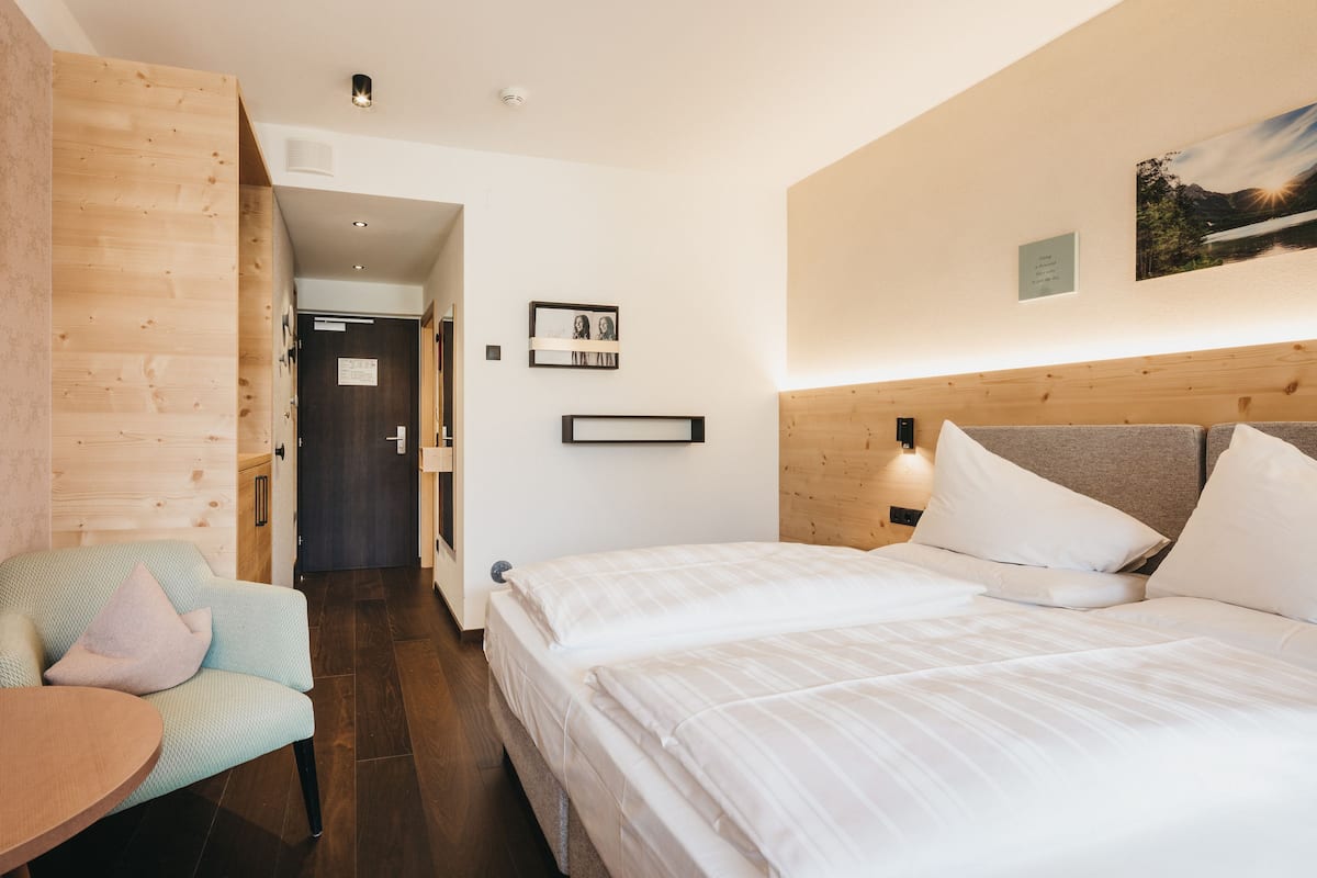 Ein Hotelzimmer mit einem Bett, einem Sessel und einer Holzwand.