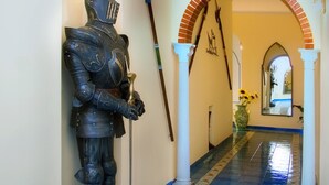 A hallway with a statue of a knight, a sword, and a spear on the wall. - Riviera B&B Rooms and Apartament SEA-VIEW (Maiori)