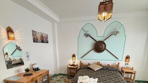 A bedroom with a bed, a desk, and a chair. There are two wall-mounted lamps and a hanging light fixture. - Riviera B&B Rooms and Apartament SEA-VIEW (Maiori)