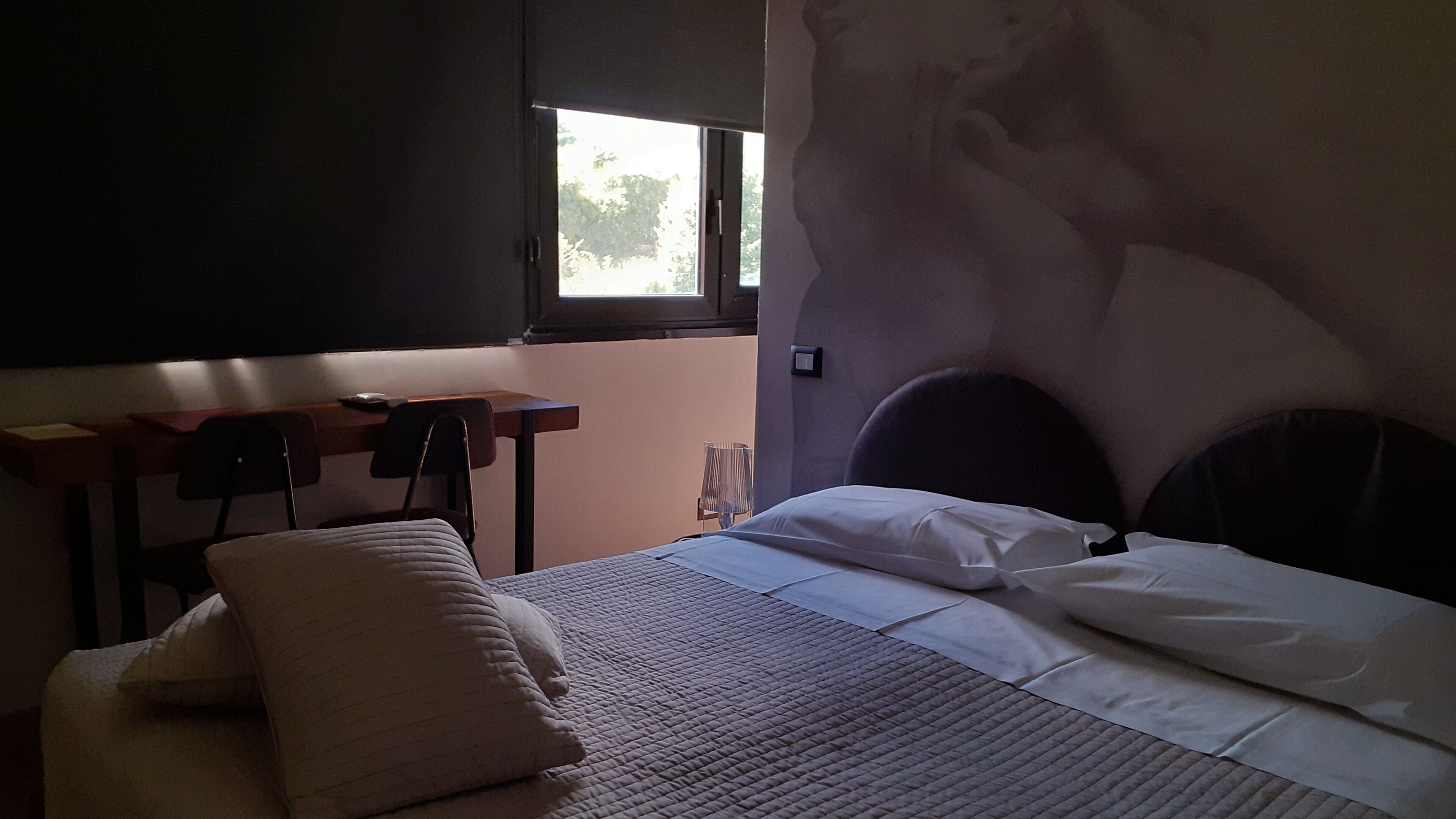 A bedroom with a bed, a desk, and a chair.