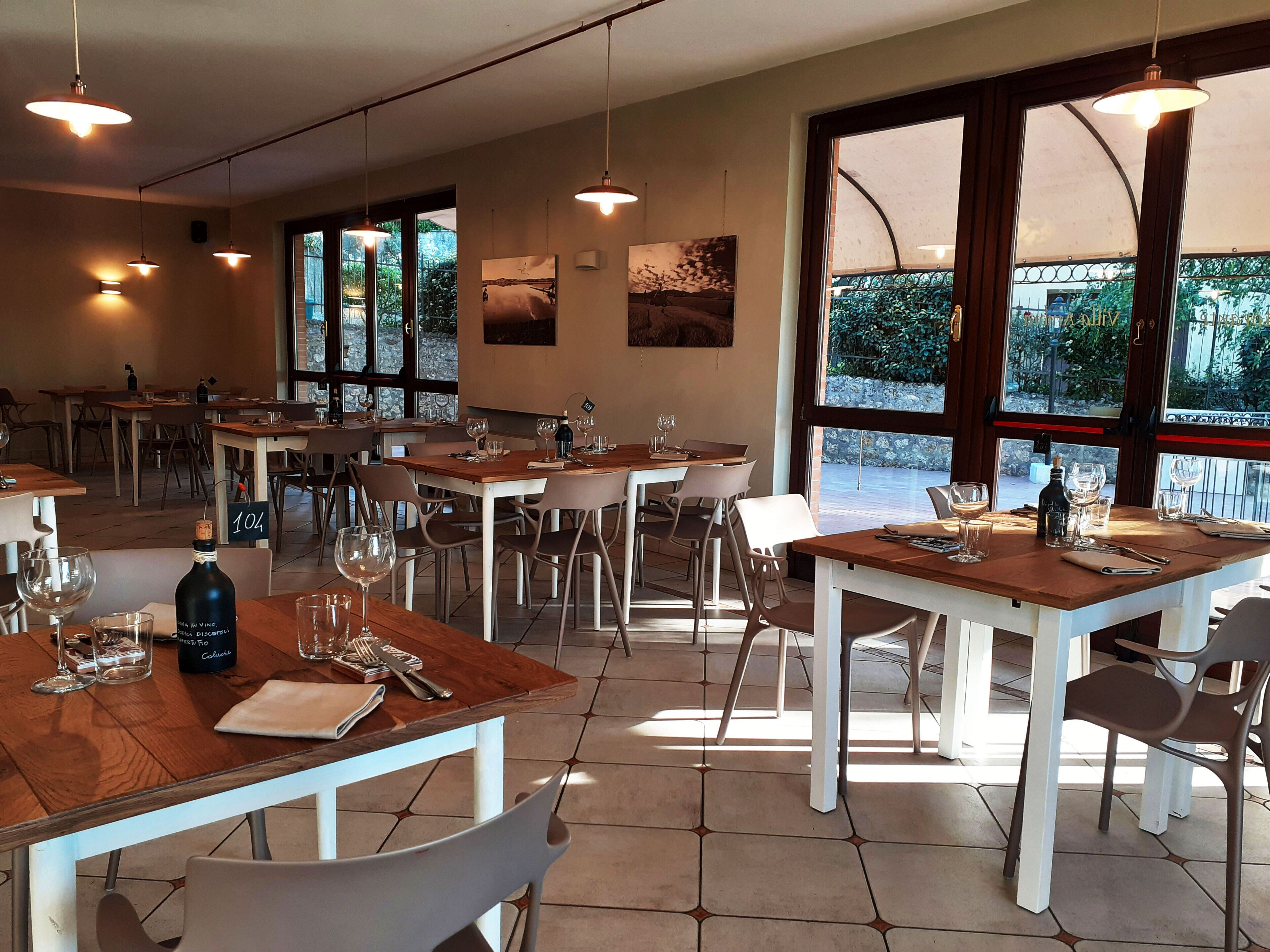 Een restaurant met meerdere tafels, stoelen en eettafels, klaar voor gasten.