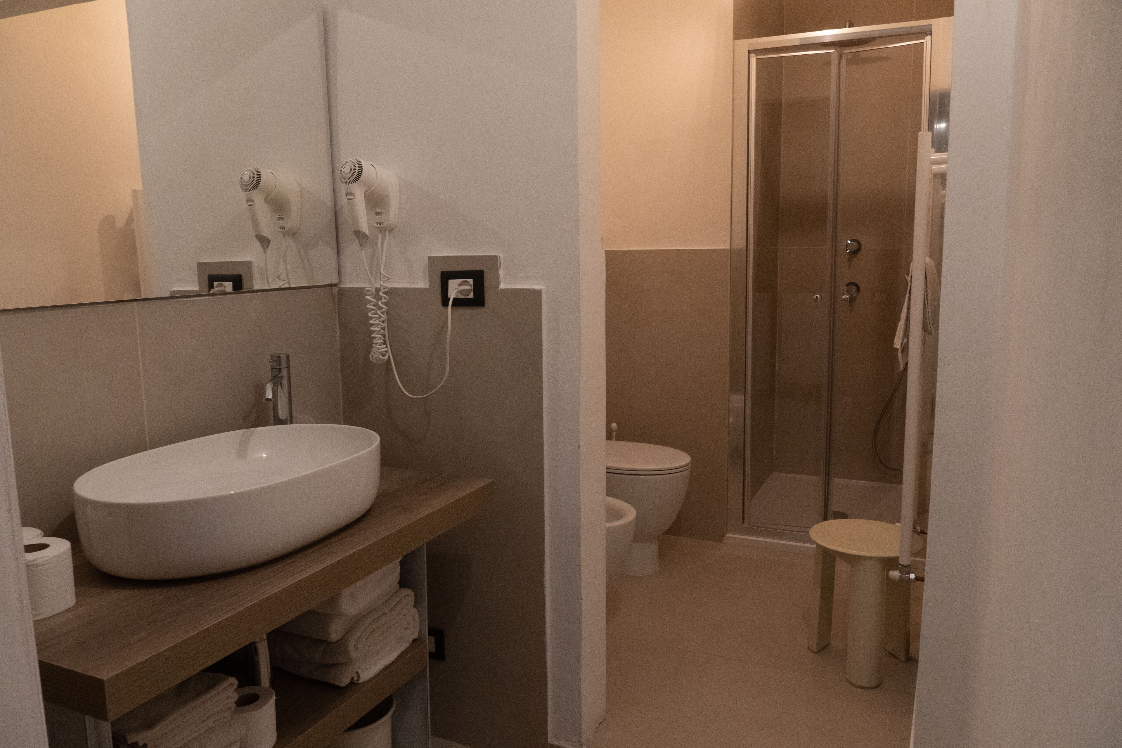 Ein modernes Badezimmer mit einem großzügigen Waschbecken, einer Toilette und einer Duschkabine.
