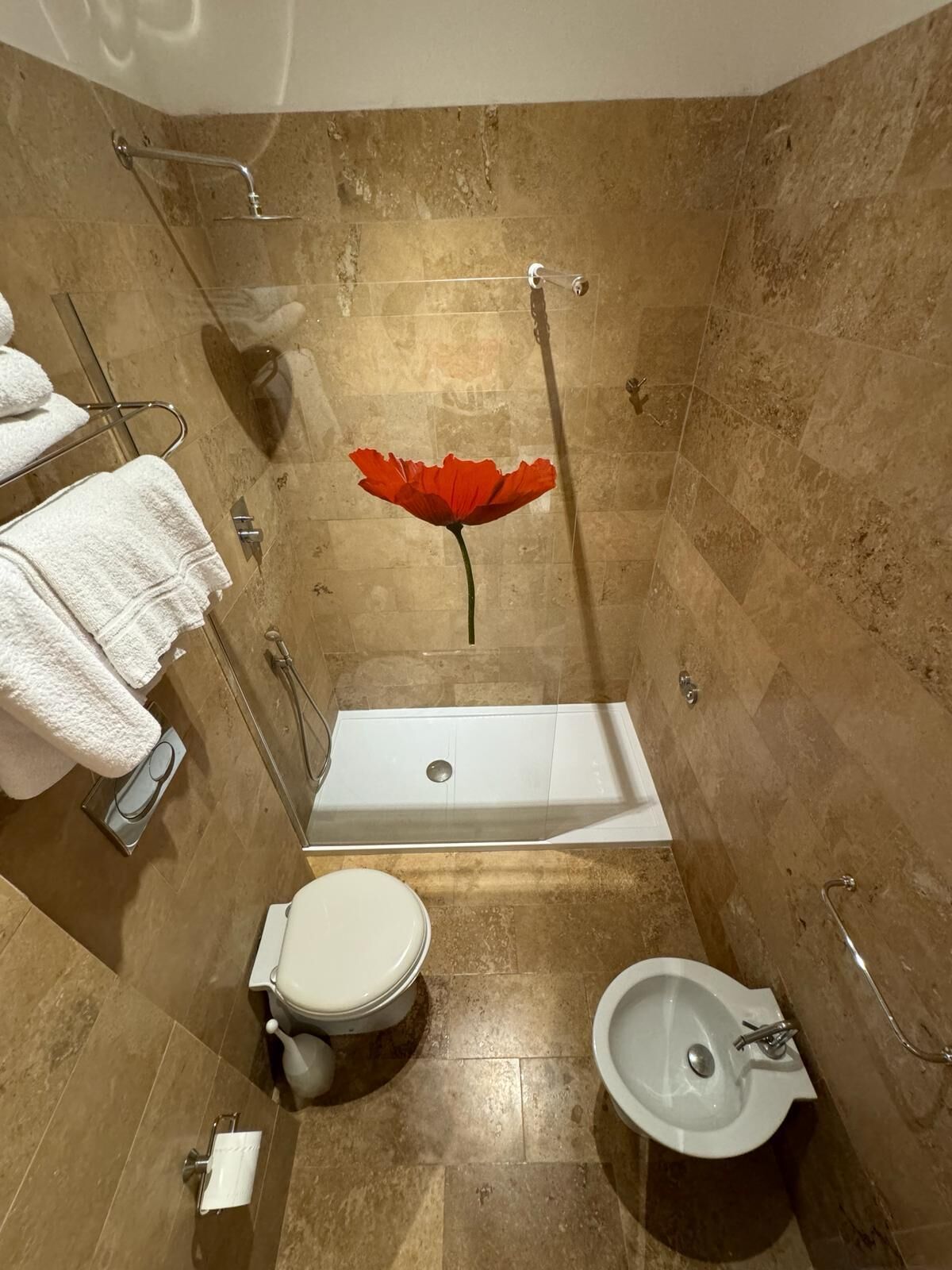 A bathroom with a bathtub, toilet, bidet, and a shower area.