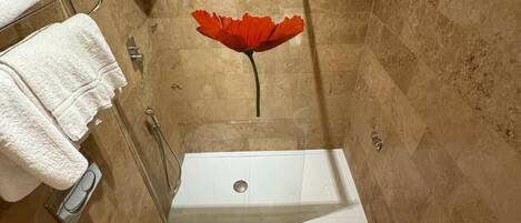 A bathroom with a bathtub, toilet, bidet, and a shower area.