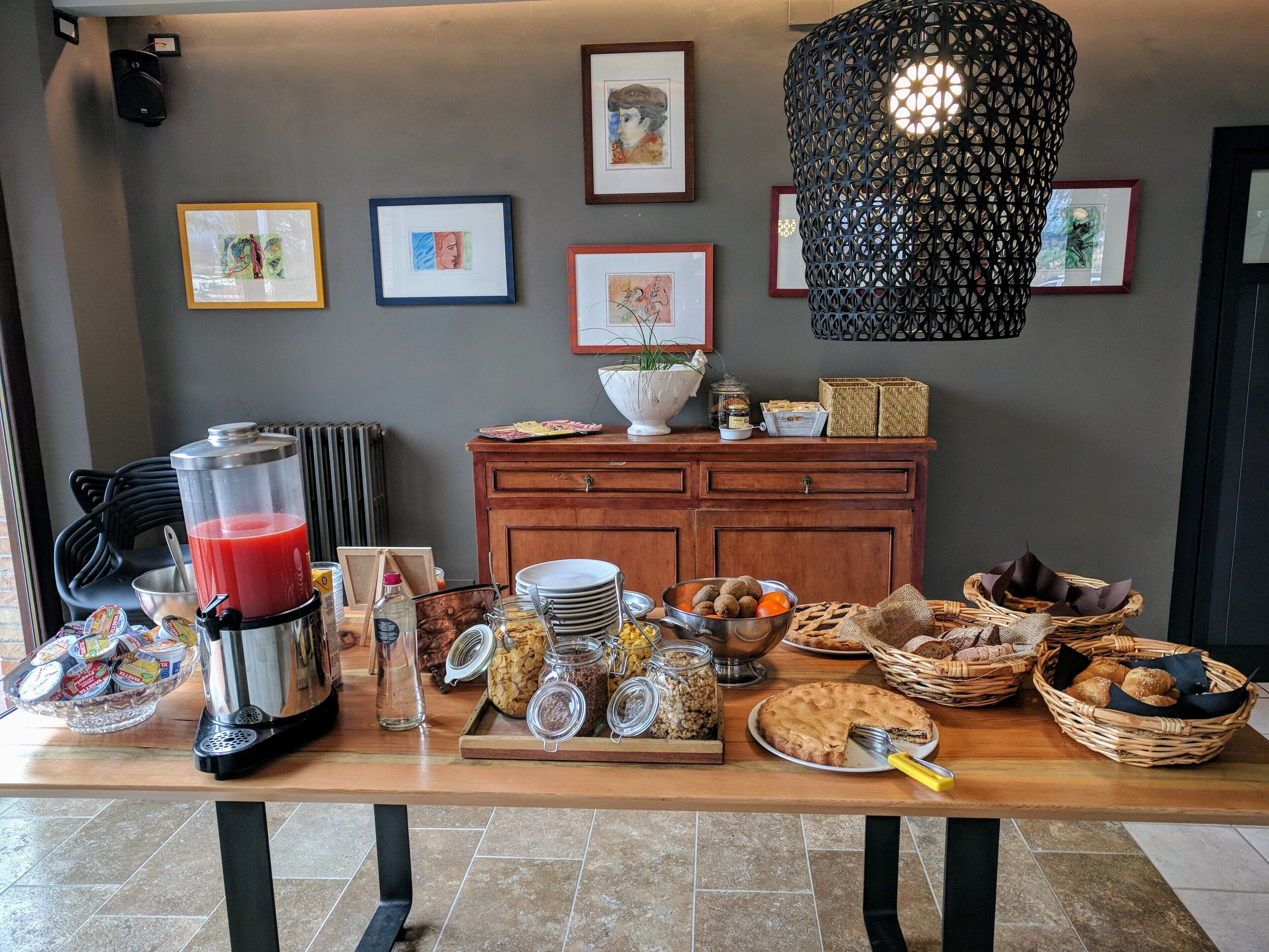 Un bufé de desayuno con diferentes opciones de comida, una máquina de café y decoración mural.