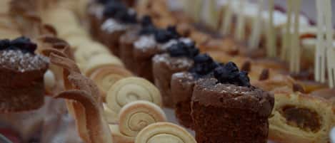 A variety of pastries displayed on a glass counter.