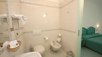 Un bagno con vasca, WC, bidet e un piccolo cestino.