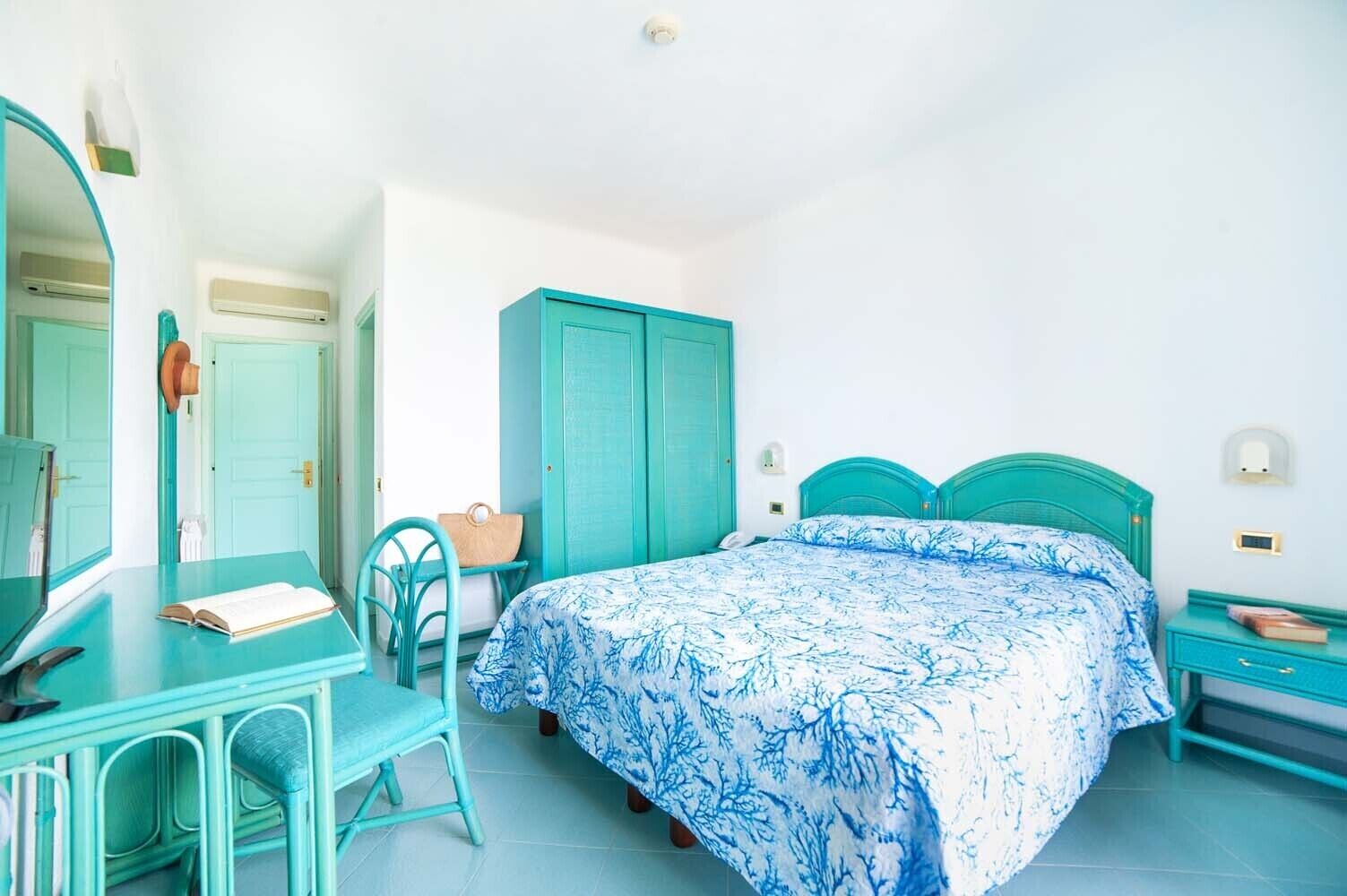 Une chambre à coucher comprenant un lit, un bureau, une chaise, une armoire et un miroir.