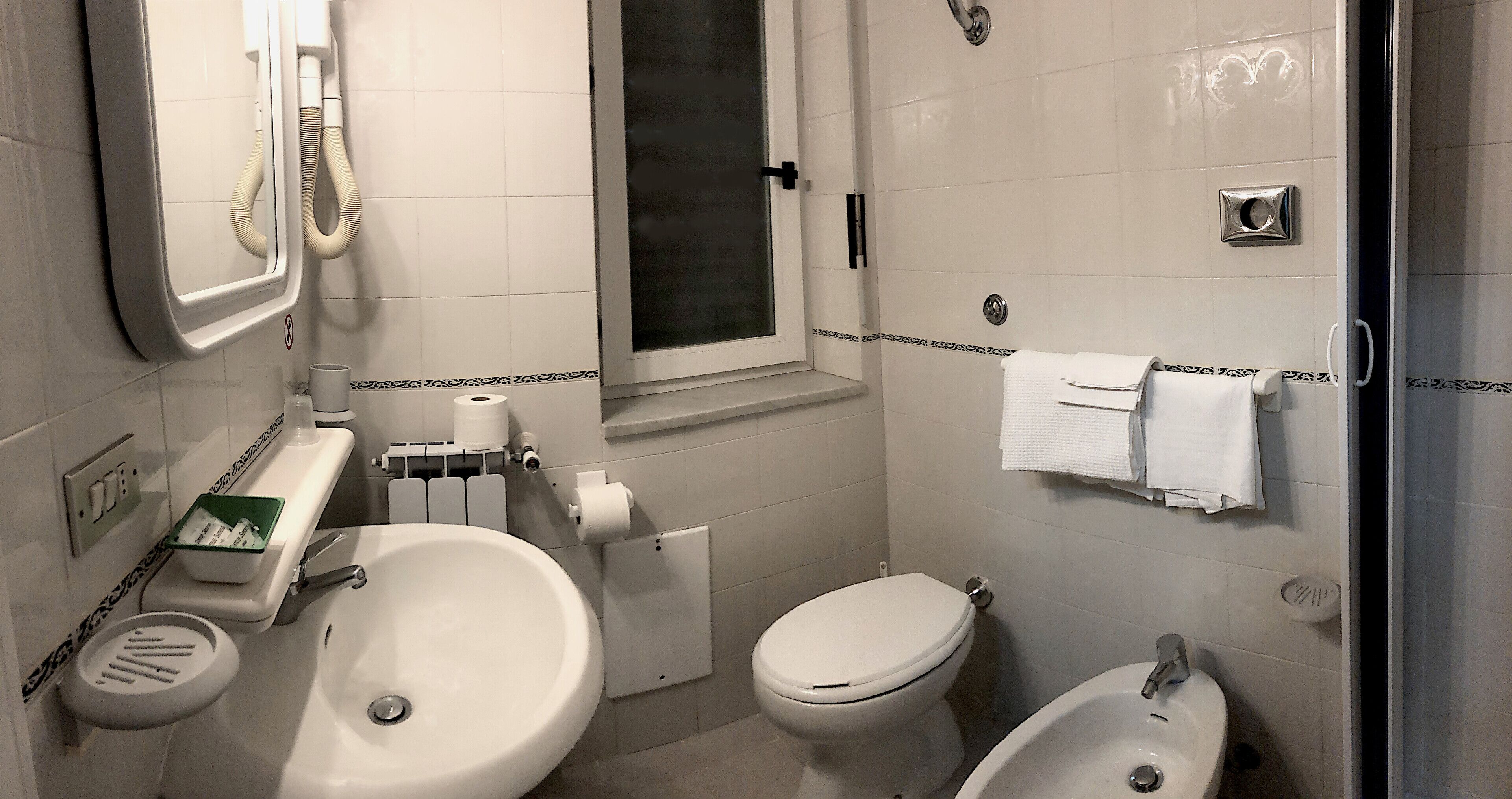 A bathroom with two sinks, a toilet, and a shower.