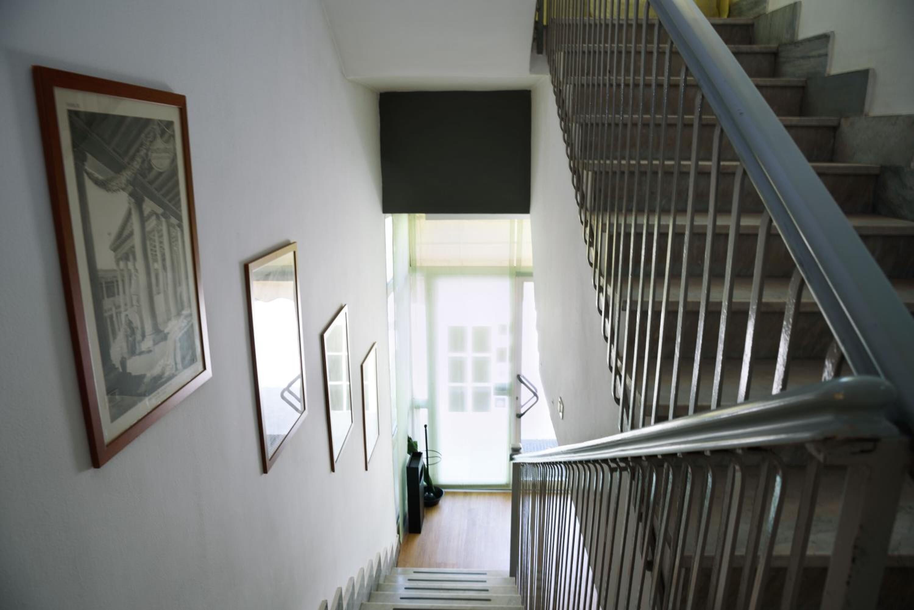 A staircase with a metal railing leading to a landing.