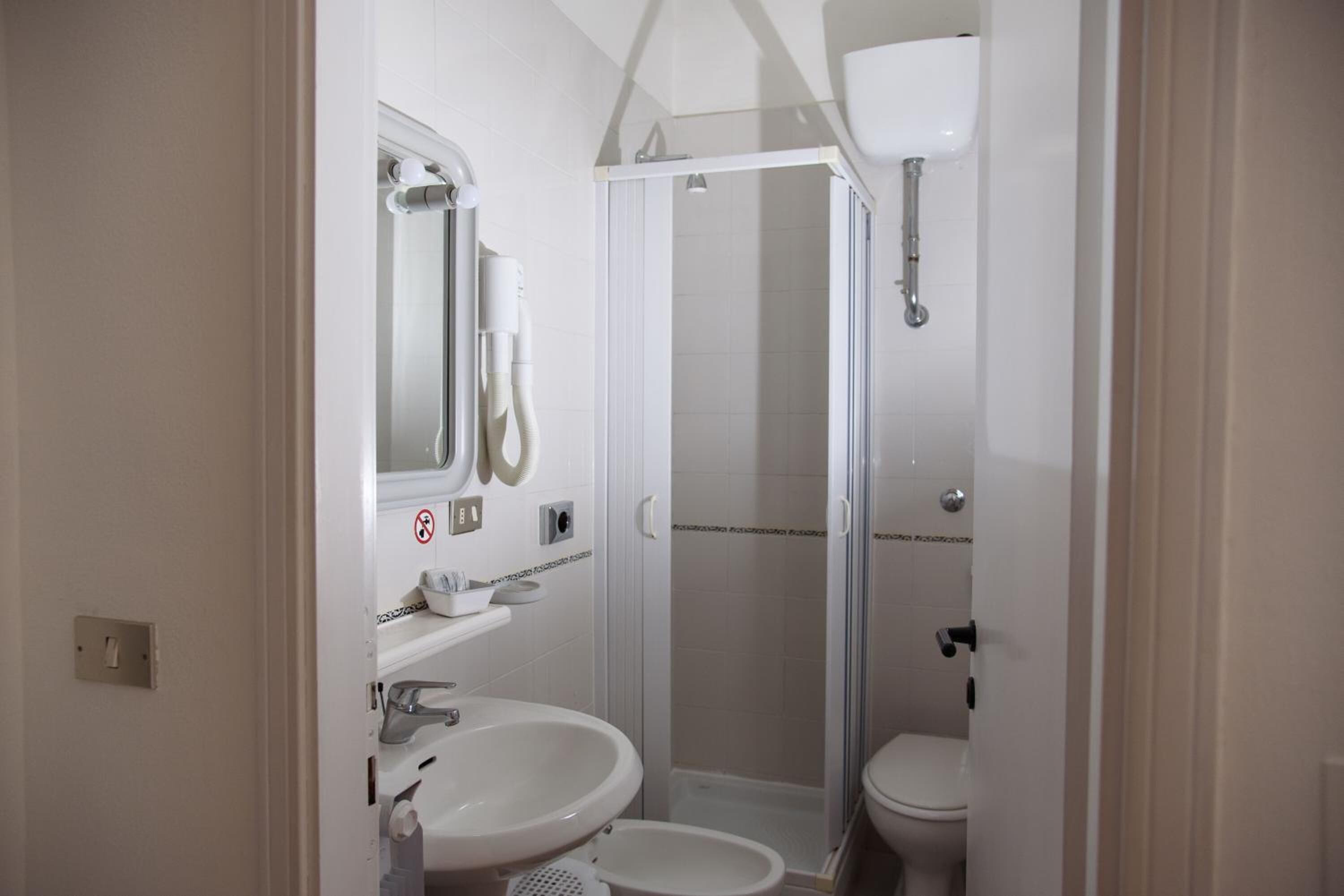 A compact bathroom with a shower, toilet, and sink.