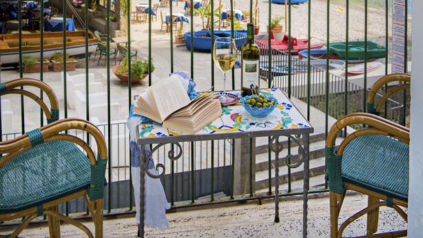 A seaside restaurant with outdoor seating, a view of the sea, and a rocky cliff backdrop. - Alfonso a Mare (Furore)