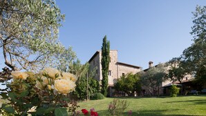 A stone building with a garden in front. - Hotel Tenuta di Canonica (Todi)