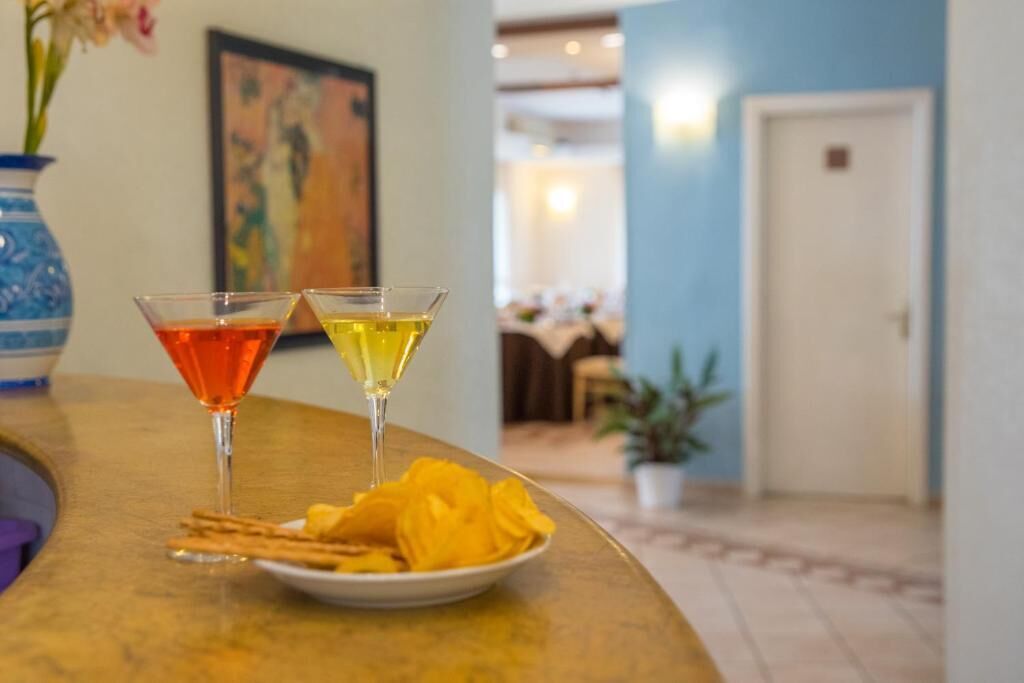 A bar area with two martini glasses, one red and one yellow, and a plate of snacks.