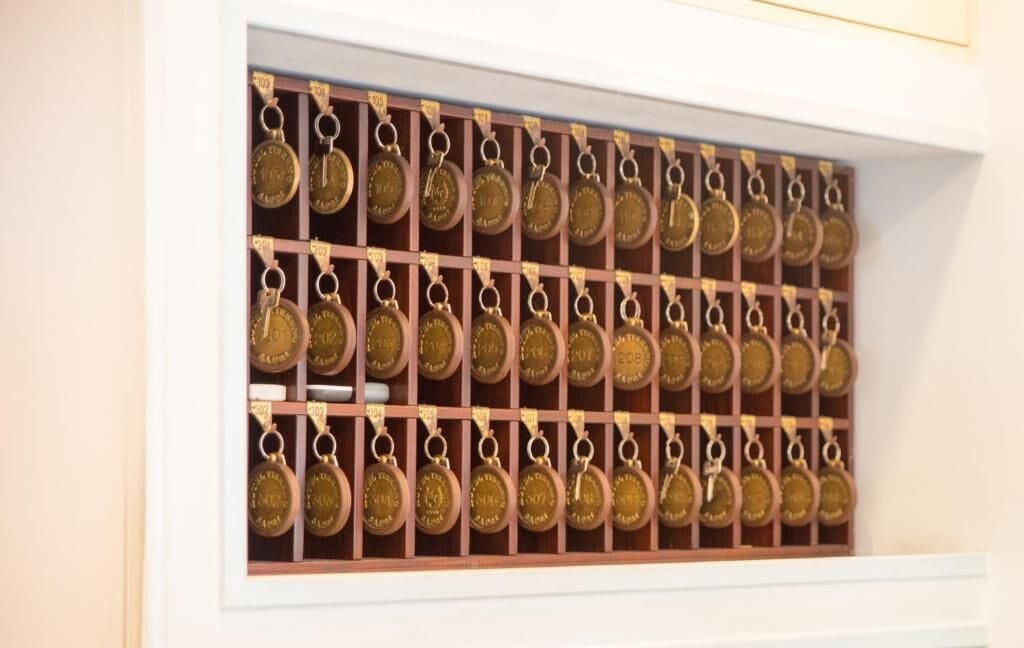 Una colección de medallas exhibidas en un estuche de madera con divisiones numeradas.