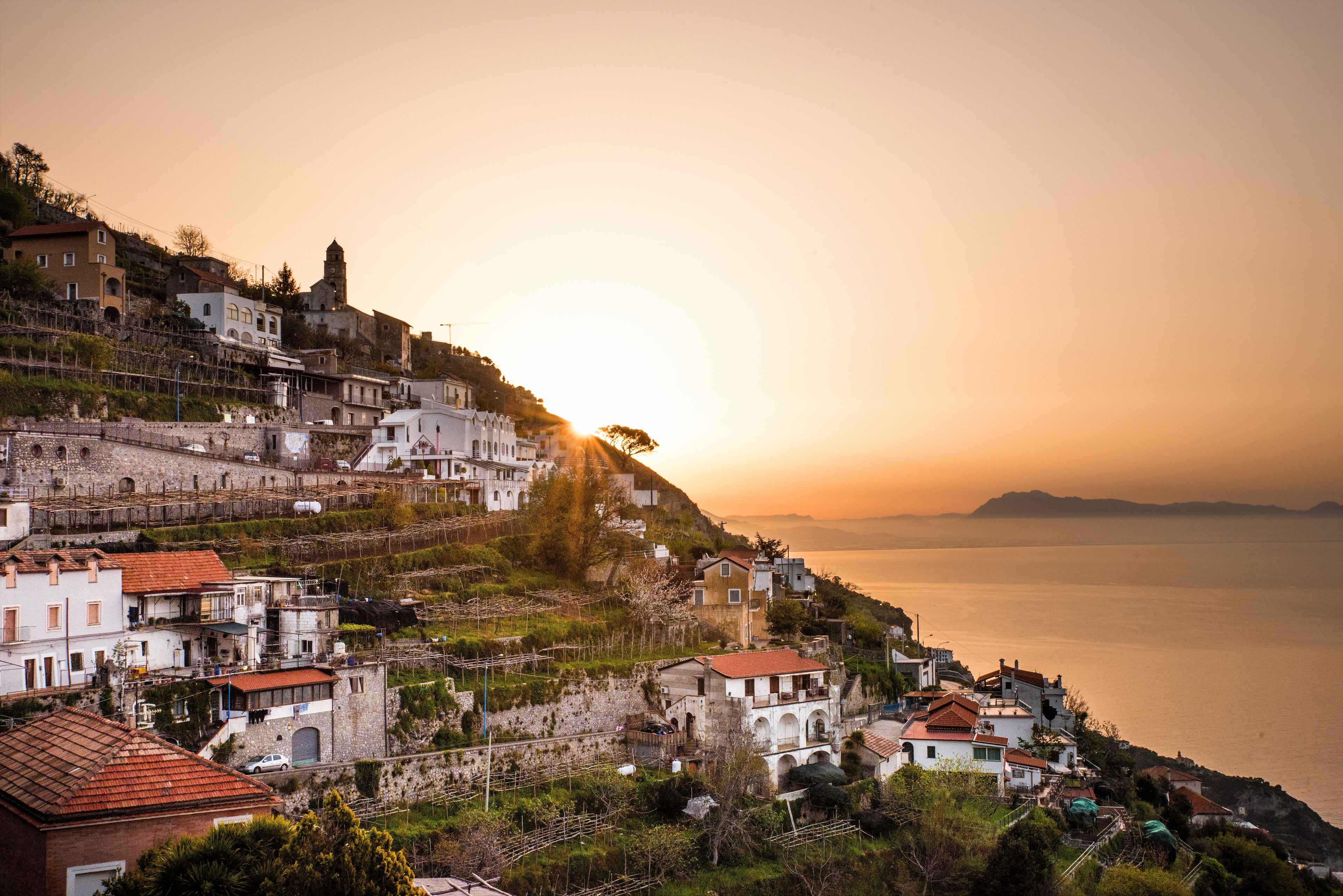 A coastal town with buildings on a hillside overlooking the sea.