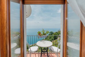 Ein Balkon mit Tisch und Stühlen, der einen schönen Meerblick bietet.