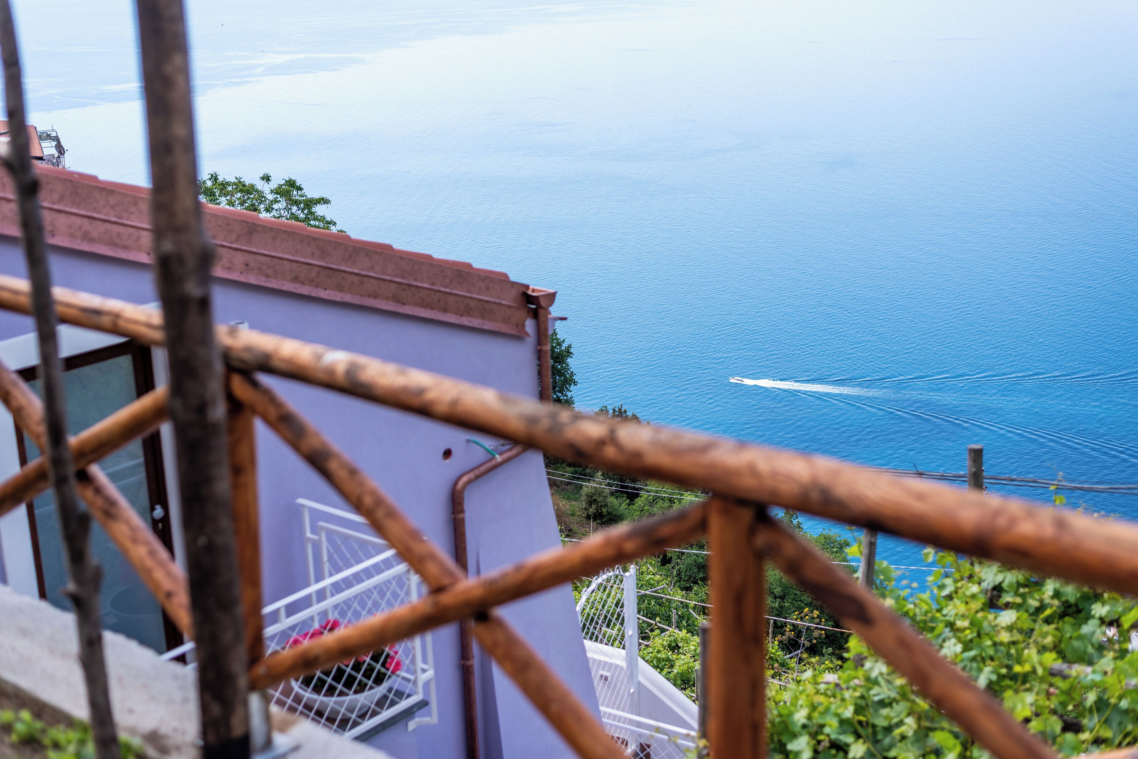A view of a coastal area with a building and a railing in the foreground.