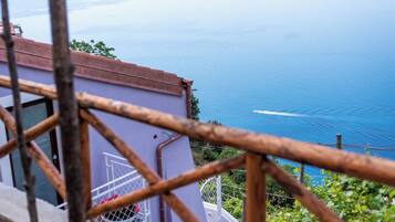 A view of a coastal area with a building and a railing in the foreground.