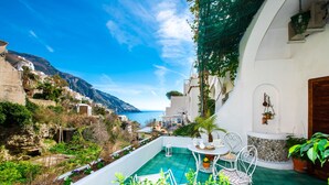 A terrace with a view of the sea, white buildings, and a stone wall. - Casa Guadagno (Positano)