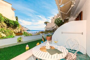 A patio with a table, a chair, and a view of the sea. - Casa Guadagno (Positano)
